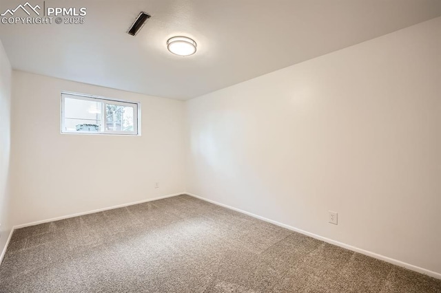 carpeted spare room featuring baseboards