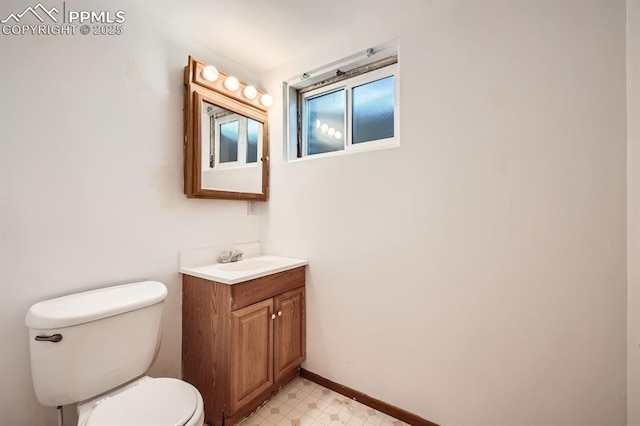 bathroom featuring toilet, tile patterned floors, baseboards, and vanity