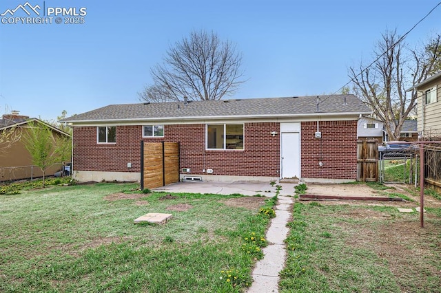 rear view of property with fence, a patio, and brick siding