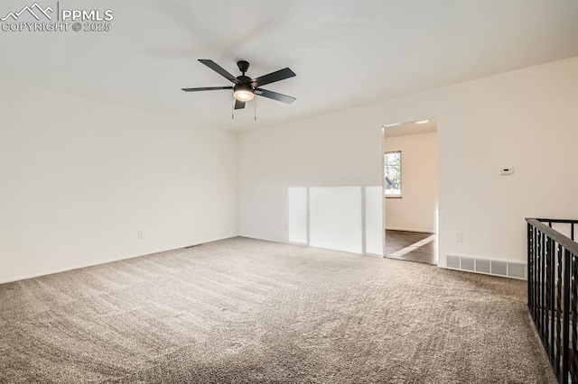 carpeted empty room featuring visible vents and a ceiling fan