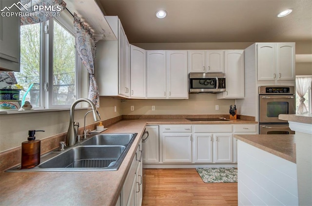 kitchen with white cabinets, stainless steel appliances, and a sink
