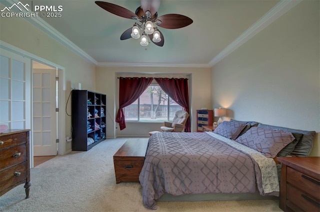 carpeted bedroom featuring baseboards, ornamental molding, and a ceiling fan