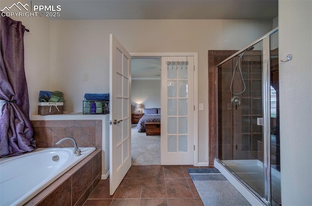 ensuite bathroom featuring a bath, tile patterned floors, a shower stall, french doors, and ensuite bath