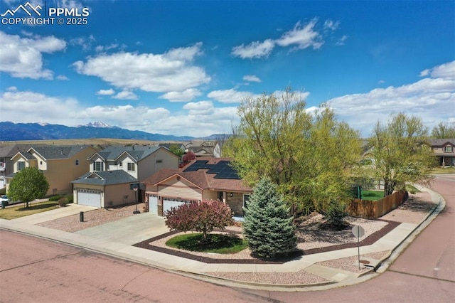 view of front of house with a garage, a mountain view, driveway, and a residential view