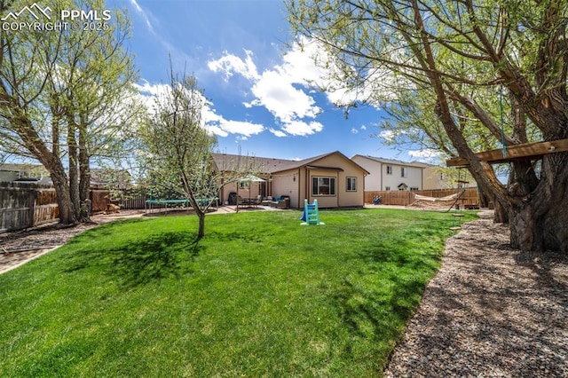 view of yard featuring a fenced backyard, a trampoline, and a patio
