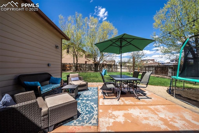 view of patio / terrace featuring a fenced backyard, a trampoline, outdoor dining area, and outdoor lounge area