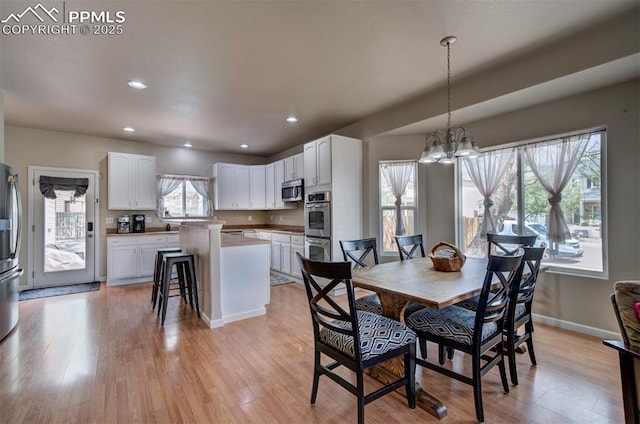 dining area with recessed lighting, light wood-style flooring, and a notable chandelier
