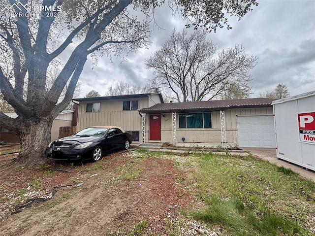 806 N Chelton Rd, Colorado Springs, CO 80909 - split level home with an attached garage, brick siding, and concrete driveway