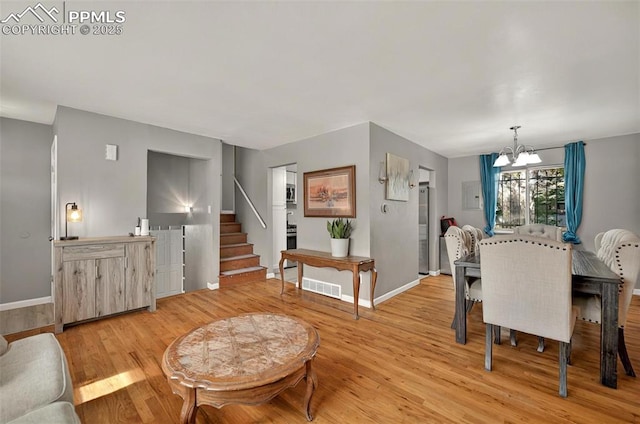 806 N Chelton Rd, Colorado Springs, CO 80909 - dining room featuring a chandelier, stairway, baseboards, and light wood-style floors
