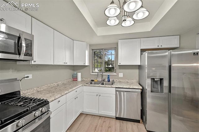 806 N Chelton Rd, Colorado Springs, CO 80909 - kitchen featuring stainless steel appliances, a sink, a tray ceiling, a chandelier, and white cabinets