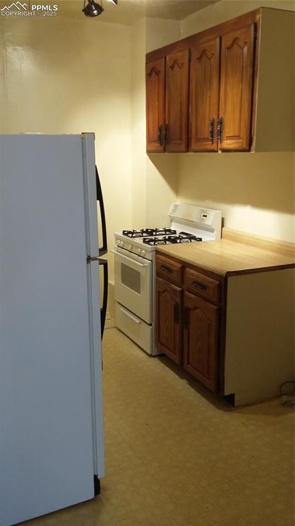 322 Platte Ct, Colorado Springs, CO 80903 - kitchen featuring white appliances, brown cabinets, light countertops, and light flooring