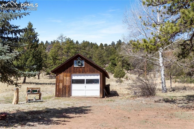 detached garage featuring dirt driveway
