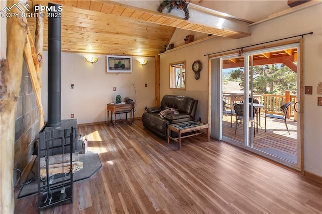 living area featuring a wood stove, wood finished floors, lofted ceiling, baseboards, and wood ceiling