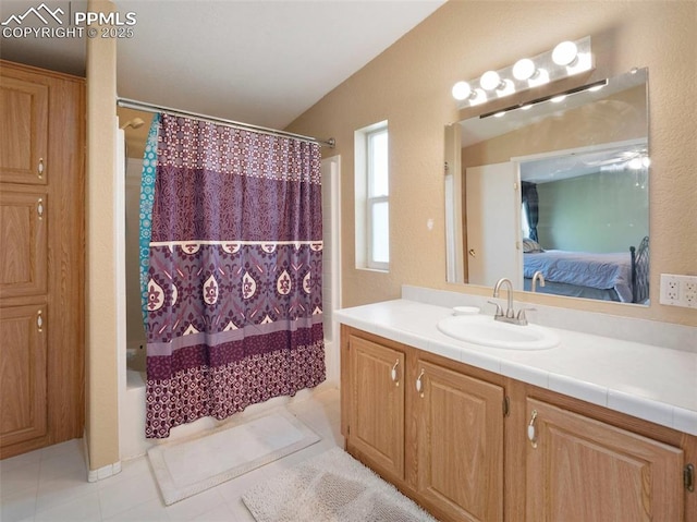 ensuite bathroom with vanity, tile patterned flooring, shower / bathtub combination with curtain, and ensuite bath