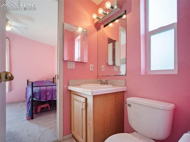 ensuite bathroom featuring vanity, plenty of natural light, a ceiling fan, and toilet