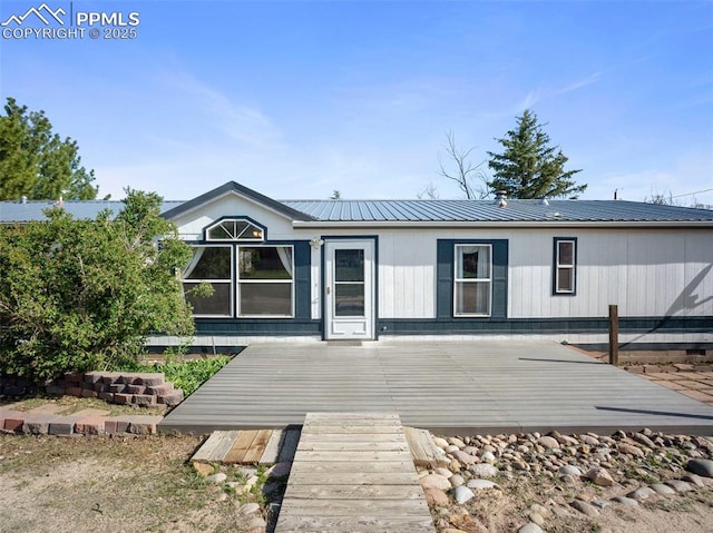 back of house with a deck and metal roof