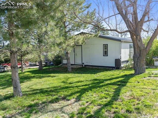 view of home's exterior featuring a lawn and central AC