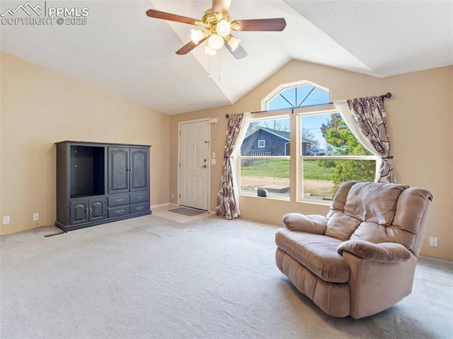 living area with ceiling fan, vaulted ceiling, and carpet