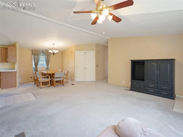 living area with visible vents, light colored carpet, lofted ceiling, and ceiling fan with notable chandelier