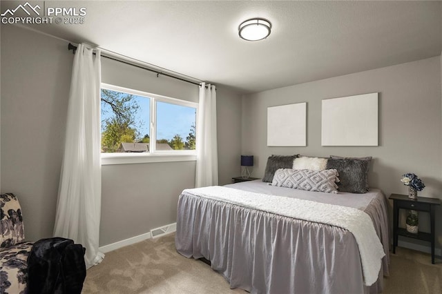 bedroom featuring baseboards, light colored carpet, and visible vents