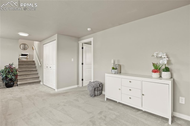 living area featuring baseboards, carpet flooring, and stairway