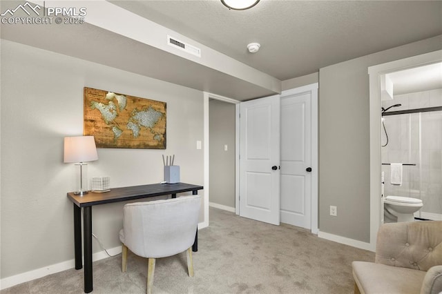 office area featuring baseboards, visible vents, and light carpet