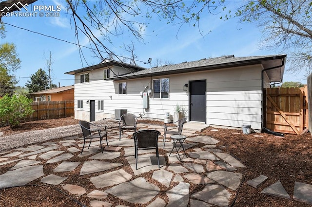 rear view of house with a patio, central AC, and a fenced backyard