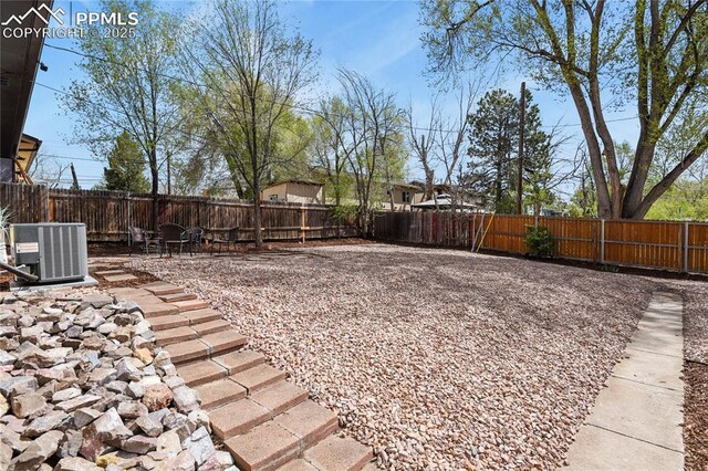 921 Holmes Dr, Colorado Springs, CO 80909 - view of yard featuring central AC, a fenced backyard, and a patio area