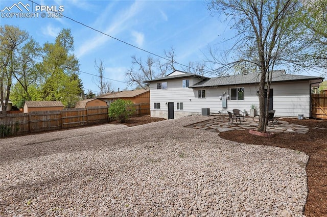 rear view of property featuring a patio, central AC unit, and a fenced backyard