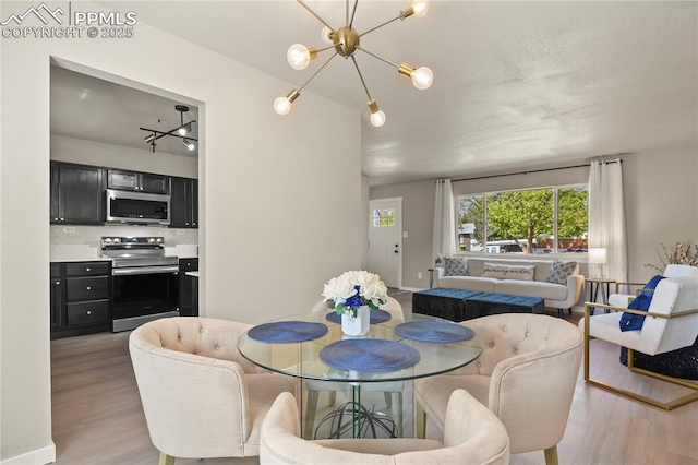 dining space with a notable chandelier and light wood-style floors