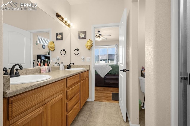 full bath with toilet, a ceiling fan, connected bathroom, and double vanity