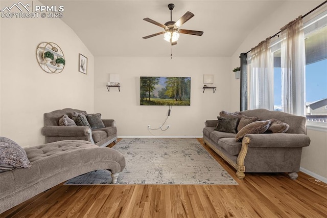 living area with vaulted ceiling, wood finished floors, a ceiling fan, and baseboards