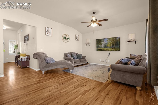 living room with light wood finished floors, a ceiling fan, baseboards, and lofted ceiling