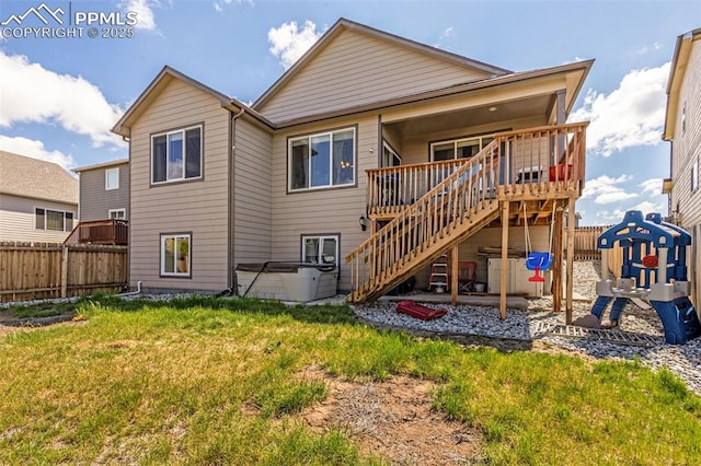 back of house featuring a hot tub, a deck, and stairway