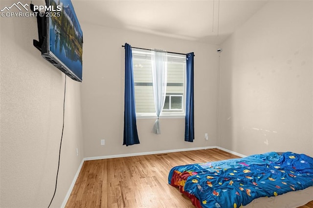 bedroom featuring wood finished floors and baseboards