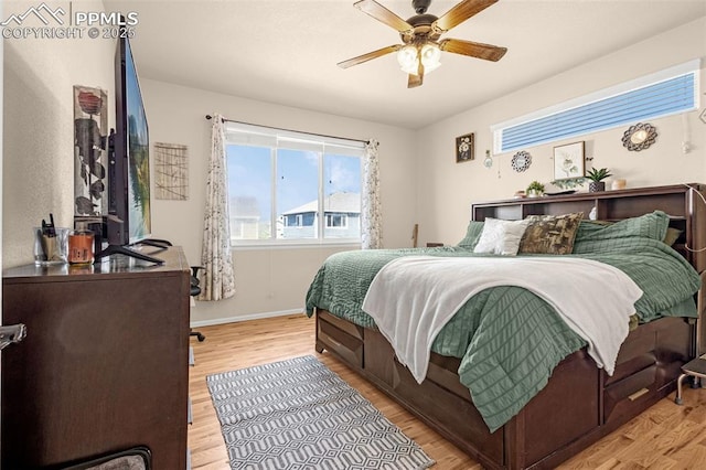 bedroom with light wood-style flooring, baseboards, and a ceiling fan