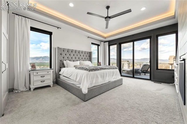 carpeted bedroom with recessed lighting, a tray ceiling, access to exterior, and a ceiling fan