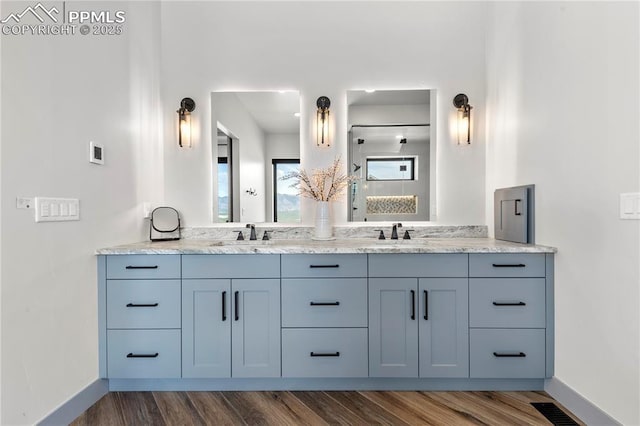bathroom with a sink, baseboards, and wood finished floors