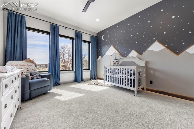 bedroom featuring carpet flooring, a nursery area, and baseboards