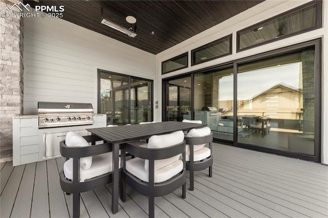 wooden terrace with an outdoor kitchen, outdoor dining space, and grilling area