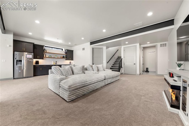 living area featuring indoor wet bar, recessed lighting, visible vents, and light colored carpet