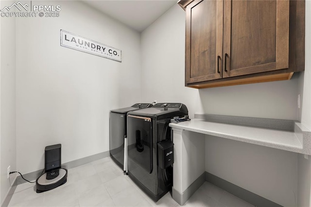 laundry area featuring baseboards, cabinet space, and washer and dryer