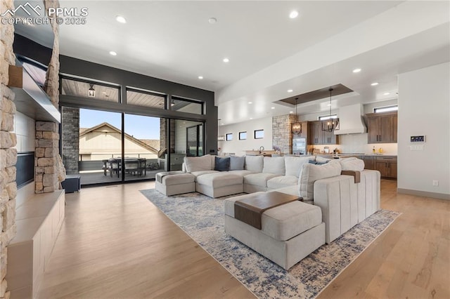 living room featuring baseboards, light wood finished floors, and recessed lighting