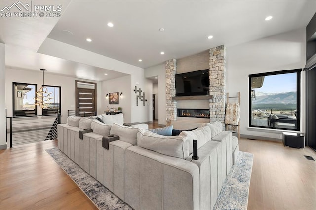 living room with light wood-type flooring, recessed lighting, and a fireplace