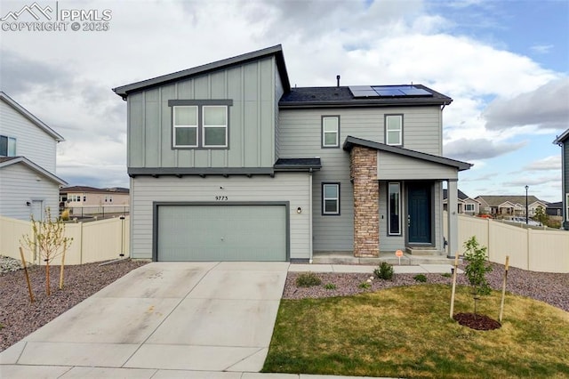 9773 Marble Canyon Way, Peyton, CO 80831 - view of front of home with board and batten siding, solar panels, an attached garage, and concrete driveway