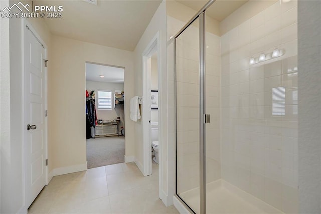 9773 Marble Canyon Way, Peyton, CO 80831 - bathroom with a spacious closet, a stall shower, toilet, baseboards, and tile patterned flooring