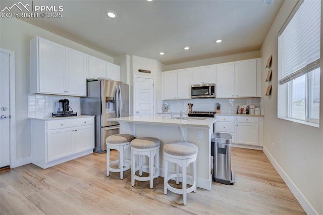 9773 Marble Canyon Way, Peyton, CO 80831 - kitchen featuring stainless steel appliances, a breakfast bar, tasteful backsplash, light countertops, and recessed lighting