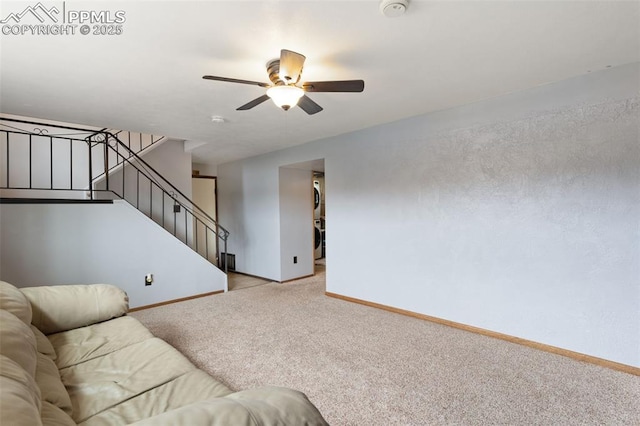 carpeted living room with baseboards, a ceiling fan, and stairs