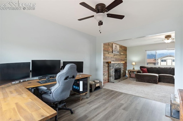 office with ceiling fan, a fireplace, and wood finished floors