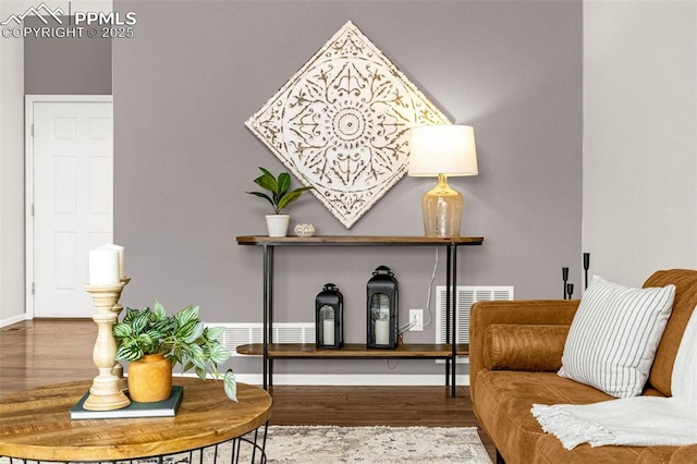 living area featuring baseboards, wood finished floors, and visible vents